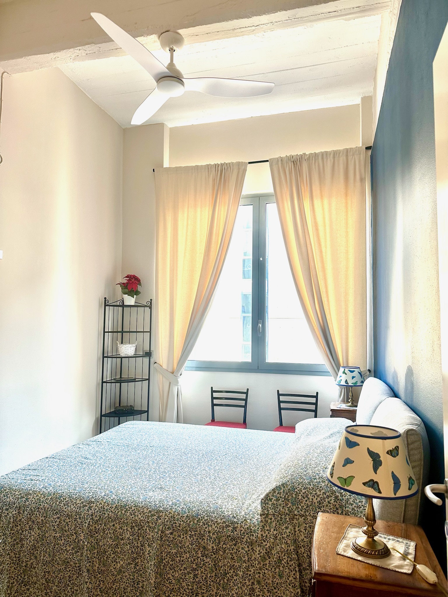 Main bedroom with double bed, ceiling fan, and natural light